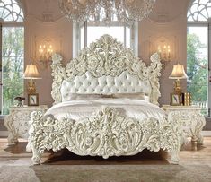 a white bed sitting in a bedroom next to a chandelier