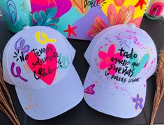 three hats with words painted on them sitting next to each other in front of a box