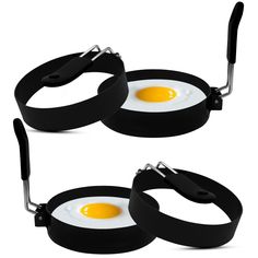 two egg frying pans with tongs are shown in the same image, one has an egg on it