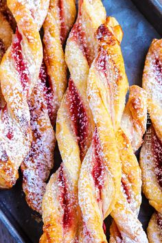 powdered sugar covered pastries sitting on top of a pan