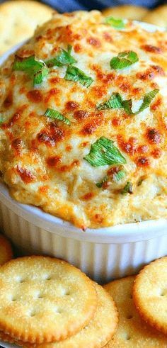 cheese dip with crackers on the side in a white casserole dish, ready to be eaten