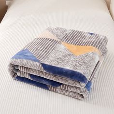 three folded blankets sitting on top of a bed