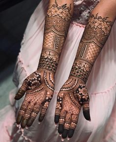 two hands with henna tattoos on them