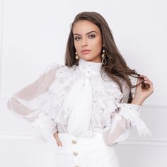 "Introducing our exquisite sheer long sleeve white Victorian shirt, a true embodiment of timeless elegance. This designer shirt features long sheer sleeves adorned with delicate ruffles at the ends, adding a touch of sophistication to your wardrobe. Ideal for transitional seasons like autumn/fall and spring, this versatile piece can be styled in multiple ways. Wear it to the office for a professional look, at business events to make a statement, or at formal gatherings to exude elegance. It's equally perfect for special occasions, parties, and festive dinners, allowing you to shine with refined charm. Key Features: 🌼 Sheer Long Sleeves with Ruffles 🍂 Ideal for Autumn/Fall & Spring 👔 Perfect for Office & Business Events 🌟 Suitable for Formal Occasions & Parties Elevate your style and em Blouse High Neck, Victorian Shirt, Formal Top, White Victorian, White Ruffle Blouse, Frilly Blouse, Formal Tops, Victorian Vintage, High Neck Top