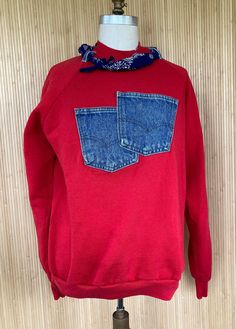 a red sweatshirt with blue denim pockets on a mannequin headdress