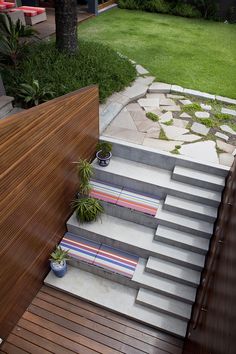 an outdoor area with stairs, potted plants and grass