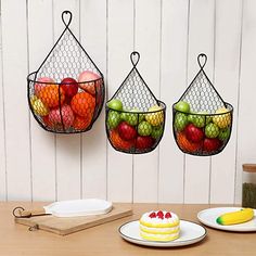 two wire baskets filled with fruit on top of a table next to plates and knives