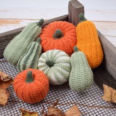 knitted pumpkins and gourds sitting on a table