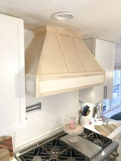 a stove top oven sitting inside of a kitchen next to white cabinets and counter tops