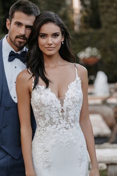 a man and woman in formal wear posing for the camera