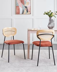 two chairs sitting next to each other in front of a table