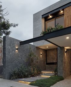 the entrance to a modern house with stone walls