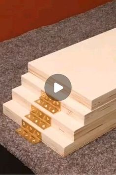 three pieces of wood are stacked on top of each other with gold rivets