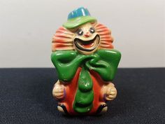 a ceramic figurine with a hat and green scarf