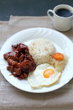 a white plate topped with rice, meat and eggs