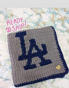 a crocheted blanket with the word ready to ship written in blue on it