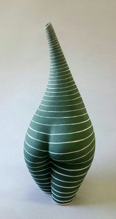 a green vase sitting on top of a white table