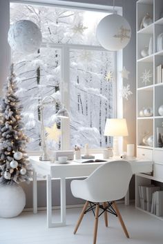 a white christmas tree sitting in front of a window next to a desk and chair