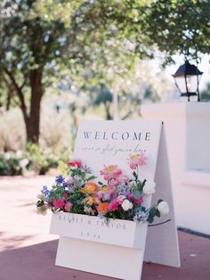 a welcome sign with flowers on it