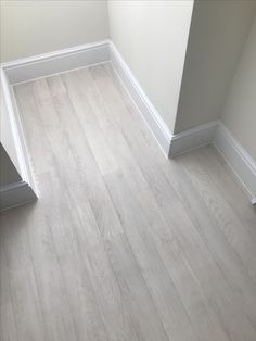 an empty room with wood flooring and white walls