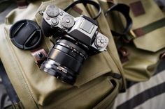 a camera sitting on top of a green bag