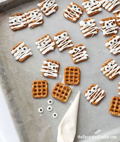 halloween pretzels with white icing on a baking sheet