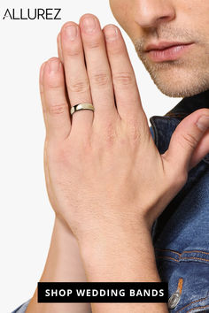 a man wearing a wedding band holding his hands together