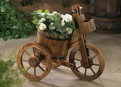 an old fashioned wooden bicycle with flowers in it