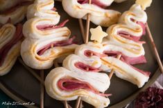 ham and cheese appetizers with toothpicks on a plate, ready to be eaten