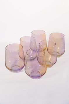 five wine glasses sitting next to each other on a white surface