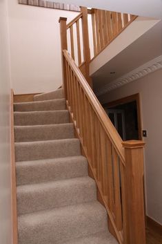 the stairs in this house are made of wood and beige carpet, with no carpeting on them