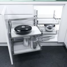 an open refrigerator door with pots and pans in the bottom drawer, on display