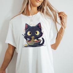 This Noodle Cat T-Shirt is perfect for cat lovers and foodie enthusiasts. The black color and cute design give off a fun and quirky vibe, making it a great addition to your casual wardrobe. Whether you're relaxing at home or out with friends, this shirt is sure to bring a smile to your face. Ideal for cat lovers and those who enjoy quirky fashion statements. Perfect for casual wear, lounging, or a fun night out. Product features - Made from durable and smooth fabric - Classic fit with crew neckl Foodie Lover, Cat Dad Shirt, Cat Apparel, Lover Clothes, Cat Mom Shirts, Quirky Fashion, Fashion Statements, Anime Cat, Cat T Shirt