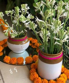 two vases filled with flowers sitting on top of a table next to each other