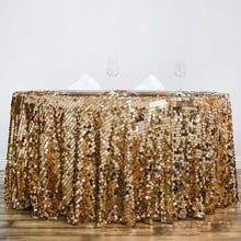 a table covered in gold sequins with two wine glasses on top