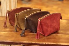 three small purses sitting on top of a wooden table