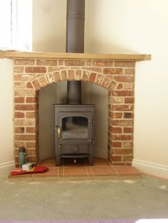 an old brick fireplace with a wood burning stove