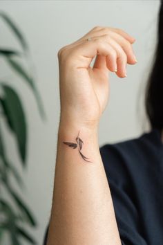 a woman's arm with a small tattoo on the left side of her wrist