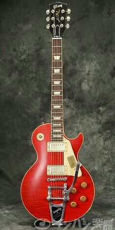 a red electric guitar sitting on top of a stand