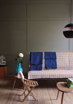 a living room with a couch, chair and table on the wooden floor next to it