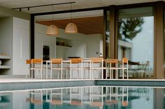 an indoor swimming pool with chairs and tables next to it