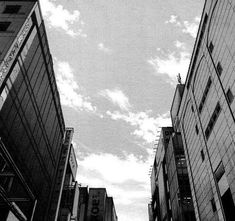 black and white photograph of tall buildings with sky in the backgroung area