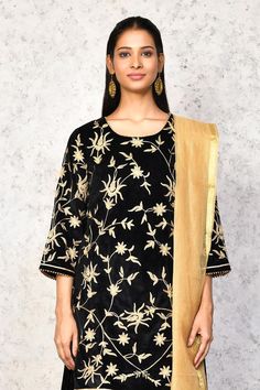 Black kurta with contrast floral embroidery. Paired with a lehenga, highlighted with floral embroidered hem. Comes along with a dupatta.
Components: 3
Pattern: Embroidery
Type Of Work: Floral
Neckline: Round Neck
Sleeve Type: Three Quarter Sleeves
Fabric: Kurta and Lehenga: Velvet, Dupatta: Chanderi, Lining: Shantoon
Color: Black
Other Details: 
Length:
Kurta: 36 inches
Lehenga: 40 inches
Occasion: Mehendi and Haldi - Aza Fashions Traditional Tops With Sheer Dupatta Drape, Traditional Tops With Sheer Dupatta, Traditional Festive Tops With Sheer Dupatta, Traditional Tops With Dupatta For Festive Occasions, Traditional Tops With Dupatta For Diwali, Traditional Festive Tops With Dupatta, Festive Traditional Drape Top With Dupatta, Festive Salwar Kameez With Cutdana Details, Black Palazzo Set With Gota Work For Eid