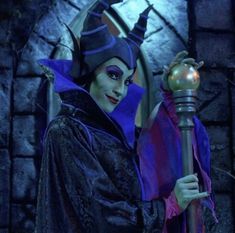 maleficent from disney's sleeping beauty is holding a lamp in front of a mirror