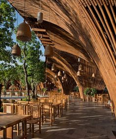 the inside of a restaurant with wooden tables and chairs, hanging from wood rafters