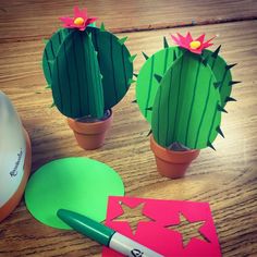 paper cut out cactus and other crafting items on a wooden table with a computer mouse