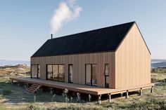 a small wooden house in the middle of an open field