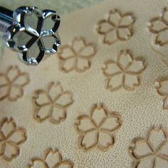 a close up view of an embroidered fabric with flowers on it and a bead in the middle