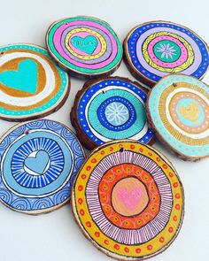 colorful painted wooden slices with hearts and arrows on them are arranged in the shape of circles