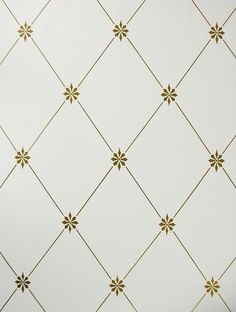 a white and gold tiled wall with flowers on it